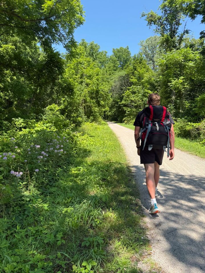 Jacob rucking a wooded rail trail